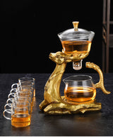 RORA gold deer tea set with six glass cups and glass infuser on a dark surface