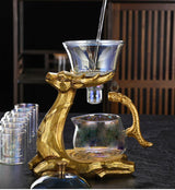 RORA iridescent glass tea set on gold deer stand, pouring water into the infuser