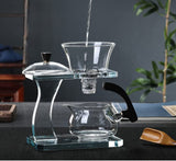 RORA glass gravity tea maker with water poured into the top bowl, wooden scoop and tray