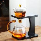 RORA glass tea set with tea leaves steeping and dripping into the pitcher on a wooden table