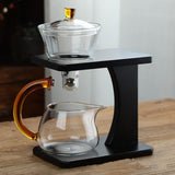 RORA glass tea set with silver ball-valve brewing bowl and amber pitcher on a wooden table