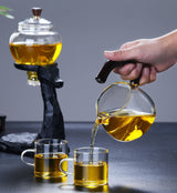 RORA glass teapot on black deer stand pouring tea into two glass cups