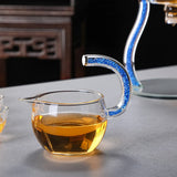 RORA glass fair cup pitcher with blue crystal-filled handle close-up, amber tea