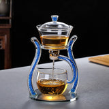 RORA magnetic glass tea set pouring amber tea from the brewing bowl into the pitcher on a dark background