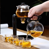 RORA magnetic water diversion tea maker pouring tea into four glass cups on a wooden tray